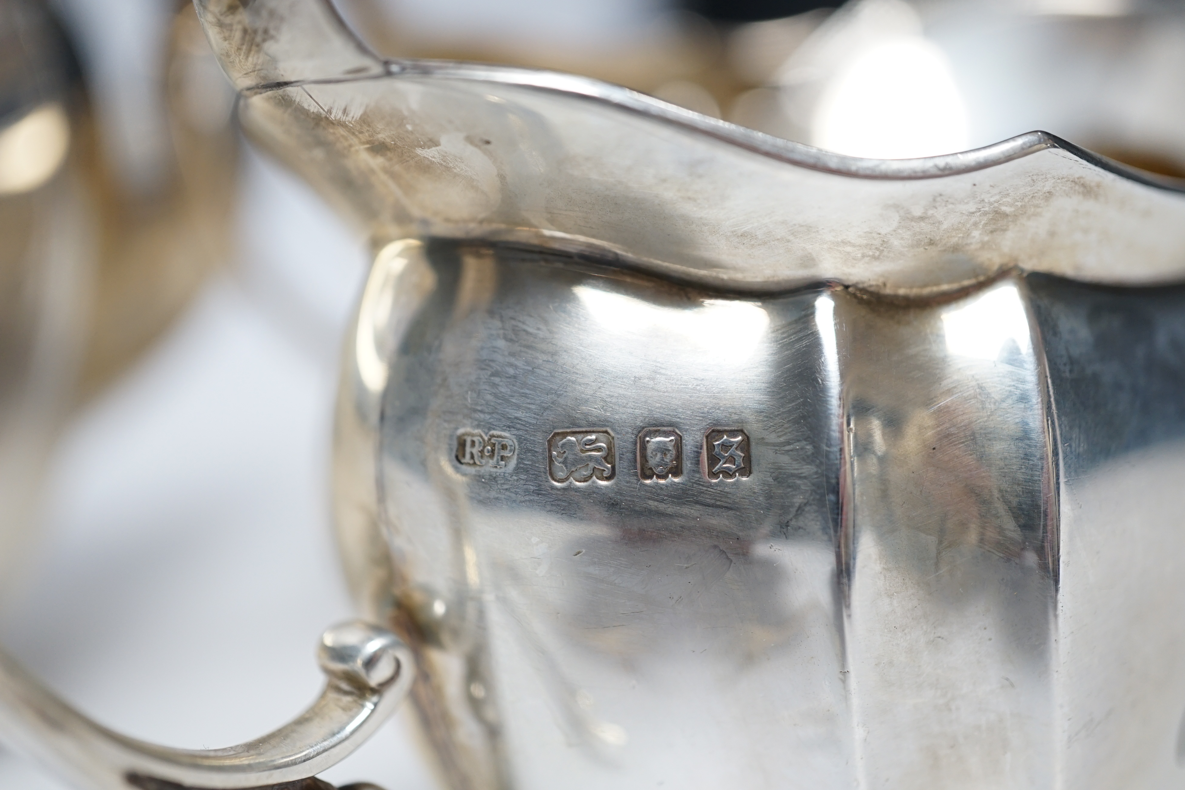 A George V three piece silver tea set by Robert Pringle & Sons, London, 1933, with engraved inscription, together with a pair of associated silver sugar tongs, gross weight 40.7oz.
